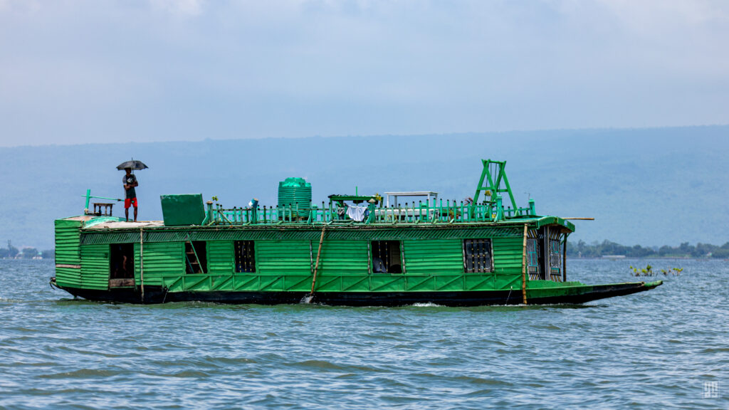 A green tourist houseboat crossing Tanguar Haor in Sunamganj, Bangladesh. Photo by Jaman | AsadSnapper.