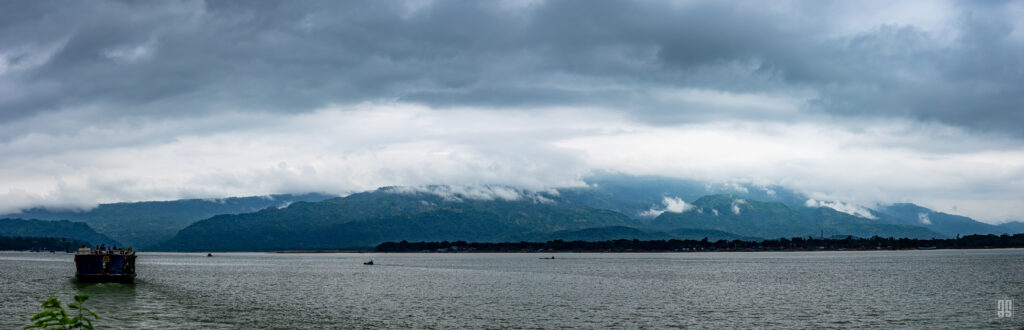 Panoramic landscape of Tanguar Haor beneath cloud-covered hills in Sunamganj, Bangladesh. Photo by Jaman | AsadSnapper.